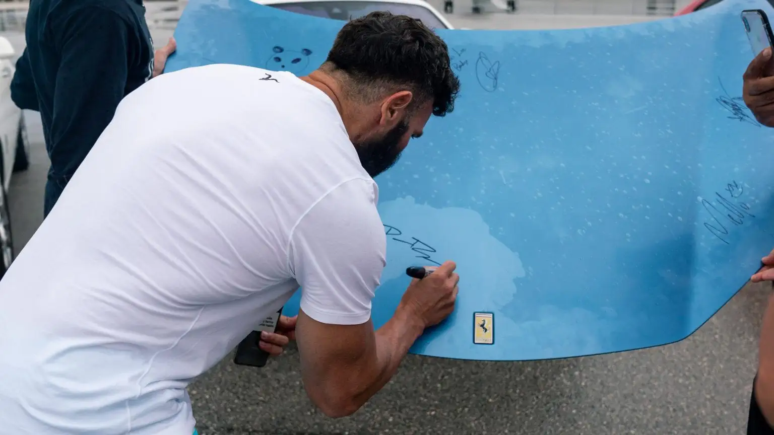 dan bilzerian signing the ferrari hood mph club