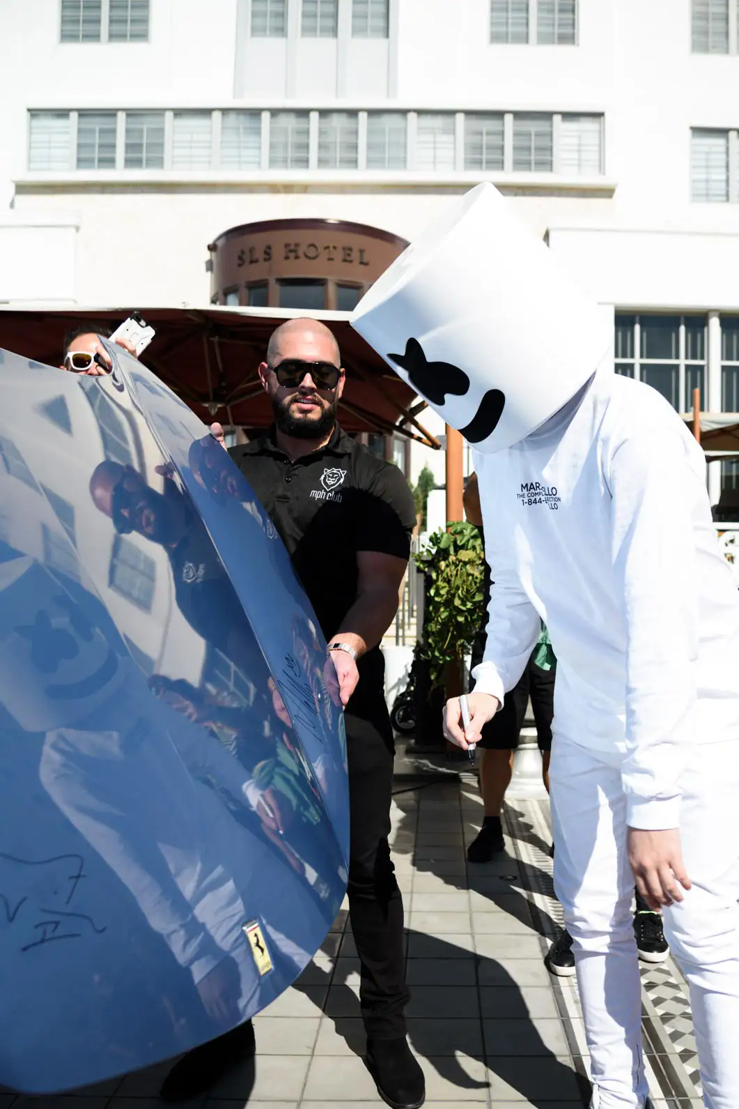 marshmello signing the blue ferrari hood mph club exotic car rentals