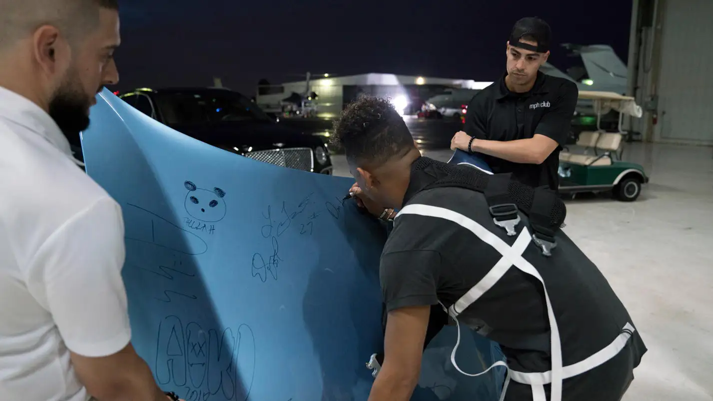 ozuna signing the ferrari hood from mph club