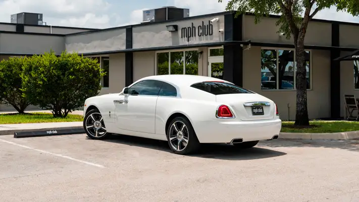White with white interior Rolls Royce Wraith rental rear view mph club
