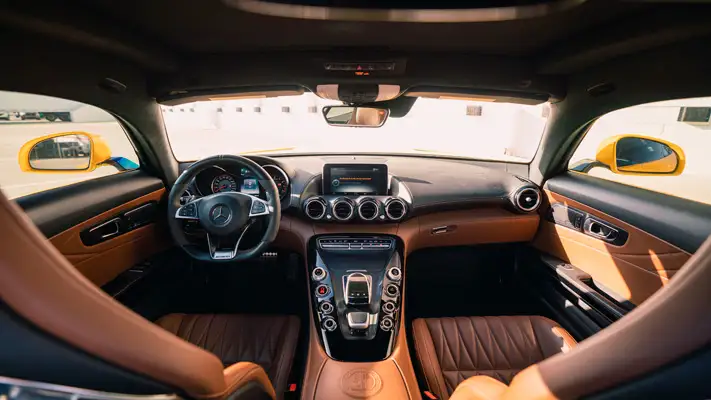 Yellow Mercedes Benz AMG GTS rental dashboard view mph club