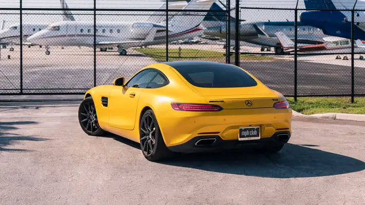 Yellow Mercedes Benz AMG GTS rental rear view mph club