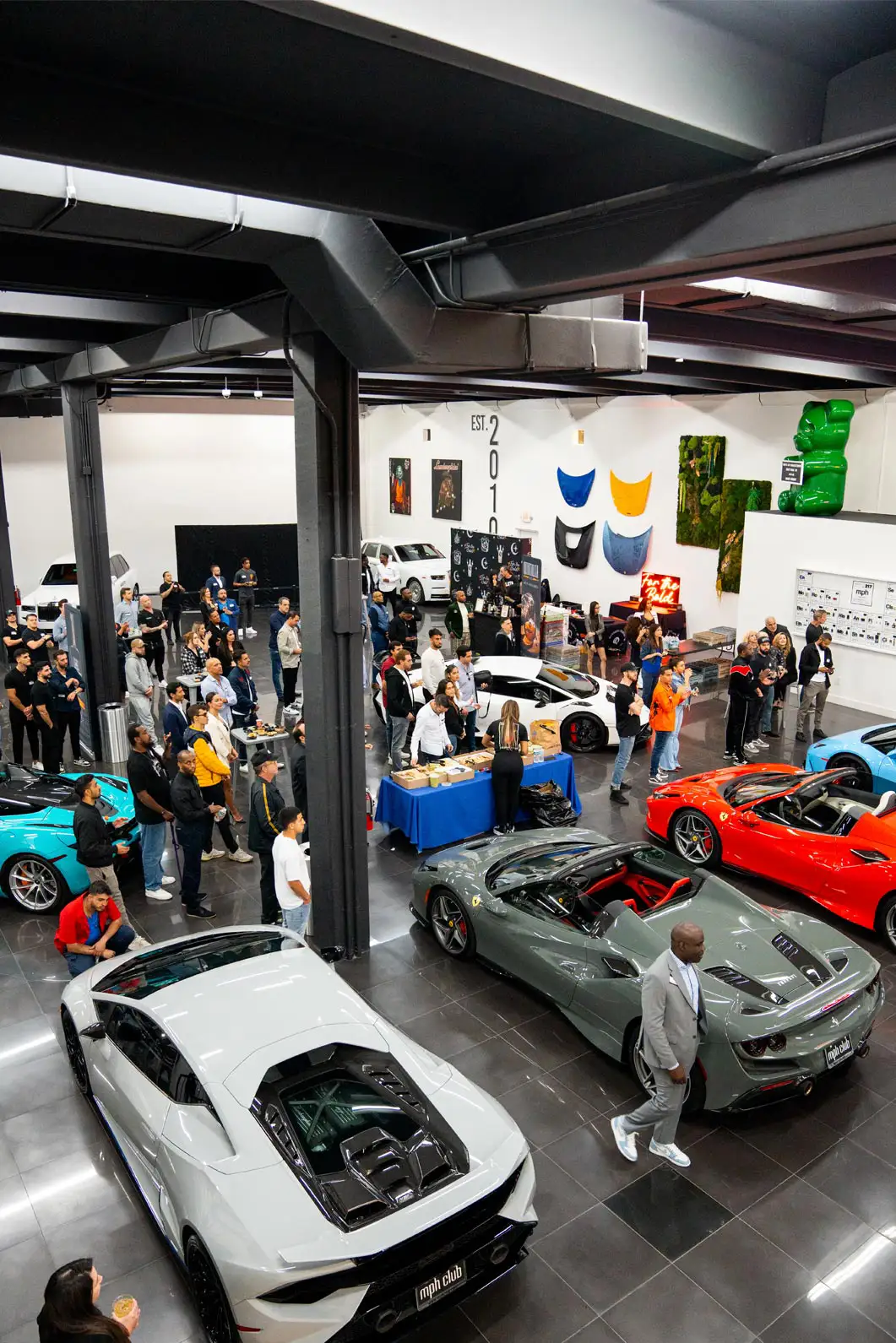Guests walking throughout the mph club showroom taking advantage of meeting new people and socializing, eating, and drinking.